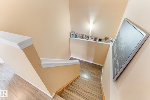 Staircase featuring wood-finish treads and risers, white painted handrails, and neutral wall tones - 173 Cornell Court Nw, Edmonton, AB - Indoor Photo Showing Other Room