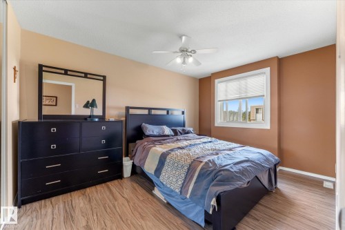 Windowed room featuring wood-finish flooring, a ceiling fan with integrated lighting, and a neutral wall color palette - 173 Cornell Court Nw, Edmonton, AB - Indoor Photo Showing Bedroom
