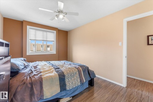 Interior room with wood-finish flooring, a white trim window, and a ceiling fan with integrated lighting - 173 Cornell Court Nw, Edmonton, AB - Indoor Photo Showing Bedroom
