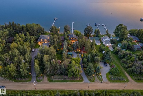 Waterfront properties featuring multiple docks, dense surrounding trees, and individual driveways - 51 Itaska Beach, Rural Leduc County, AB 