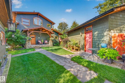 Stone pathway leading to a front porch with stone columns and wood framing - 51 Itaska Beach, Rural Leduc County, AB 