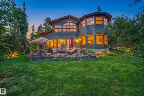 Multi-level exterior with shingle siding, a stone foundation, and a multi-pane arched window - 51 Itaska Beach, Rural Leduc County, AB 