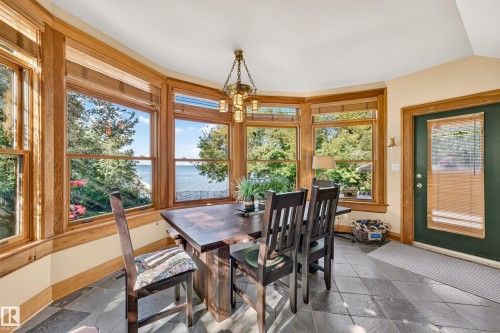 Bay window with wood trim, slate tile flooring, and a glass-paneled exterior door - 51 Itaska Beach, Rural Leduc County, AB 