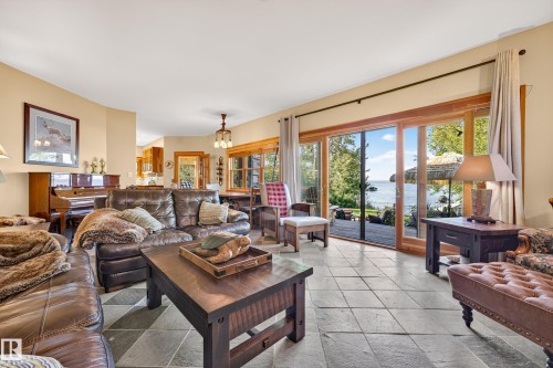 Stone tile flooring complemented by a prominent wood-frame sliding glass door leading to an outdoor deck - 51 Itaska Beach, Rural Leduc County, AB 