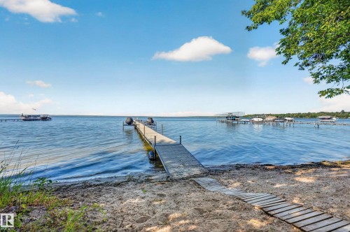 Private sandy beach, extensive dock system, tranquil waterfront, boat lifts, and direct water access - 51 Itaska Beach, Rural Leduc County, AB 