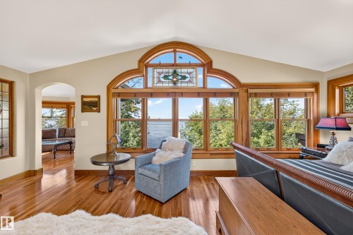 Expansive window wall with arched transom, stained glass accents, and wood trim - 51 Itaska Beach, Rural Leduc County, AB 