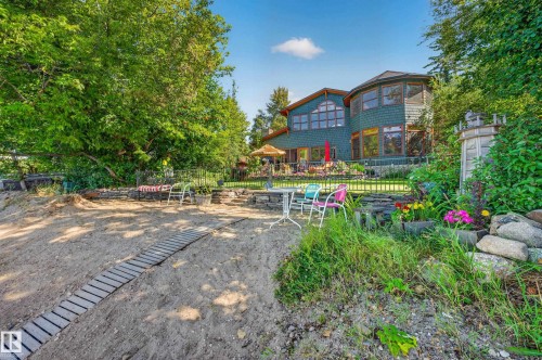 Sand shoreline with a wooden pathway and surrounding mature trees - 51 Itaska Beach, Rural Leduc County, AB 