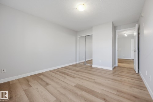Light wood-finish flooring, white walls, and a ceiling-mounted light fixture - #122 240 Spruce Ridge Rd, Spruce Grove, AB 