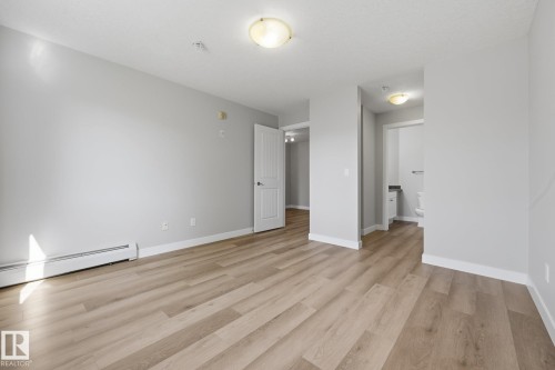 Wood-finish flooring, white trim, flush mount lighting, and interior doors - #122 240 Spruce Ridge Rd, Spruce Grove, AB 