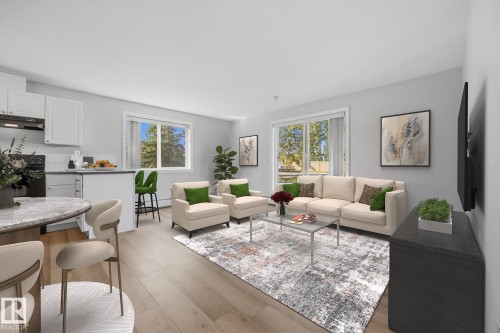 Open-concept living area with wood-finish flooring, white cabinetry, a kitchen island, and a sliding glass door - #122 240 Spruce Ridge Rd, Spruce Grove, AB 