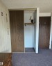 Sliding closet doors with wood-finish panels, built-in shelving, and a hanging rod - 14674 54 Street Northwest, Edmonton, AB 