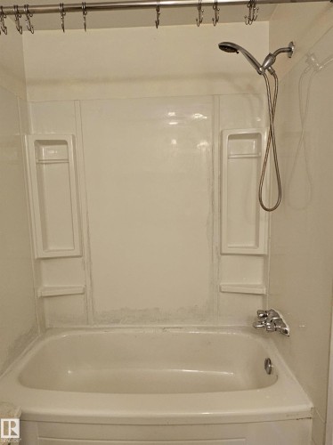 Bathtub with integrated shelving and a handheld shower fixture - 14674 54 Street Northwest, Edmonton, AB 