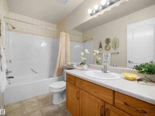 White integrated tub and shower combination with tiled surround - #206 12111 51 Av Nw, Edmonton, AB 