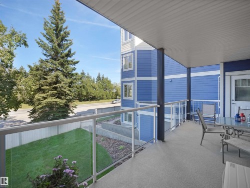 Covered balcony with glass panel railing and textured flooring - #206 12111 51 Av Nw, Edmonton, AB 