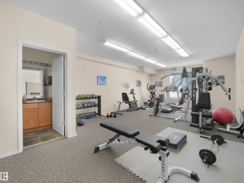 Fitness area featuring carpeted flooring and fluorescent overhead lighting - #206 12111 51 Av Nw, Edmonton, AB 