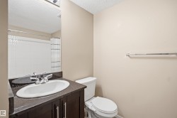 Vanity with integrated sink, dark wood-finish cabinetry, and stone-look countertop - 
