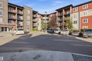 Multi-story building featuring balconies, a paved parking area, and an entrance with prominent building numbering - #225 1510 Watt Dr Sw, Edmonton, AB 
