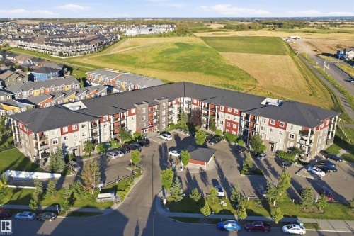 Multi-story residential building featuring balconies, ample surface parking, and perimeter landscaping - #225 1510 Watt Dr Sw, Edmonton, AB 