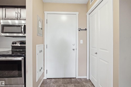 Stainless steel microwave, stainless steel range, and wood-finish cabinetry - #225 1510 Watt Dr Sw, Edmonton, AB 