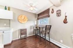 Window with a woven blind, white ceiling fan, and wood-finish flooring - 