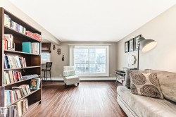 Wood-finish flooring throughout, light neutral wall paint, and a sliding glass door to an exterior balcony - 