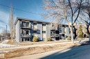 Multi-story building featuring a gray brick exterior, multiple balconies with black railings, and a sidewalk along the property - #302 10606 123 St Nw, Edmonton, AB 