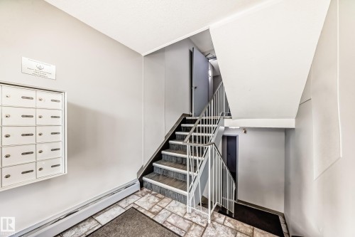 Multi-unit mailboxes, tiled flooring, painted walls, and a metal-railed staircase - #302 10606 123 St Nw, Edmonton, AB 