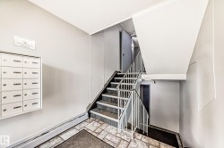 Multi-unit mailboxes, tiled flooring, painted walls, and a metal-railed staircase - 