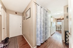 Wood-finish flooring throughout, white interior doors, and a kitchen featuring white cabinetry - 