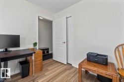 Wood-finish flooring with white walls and a white interior door - 