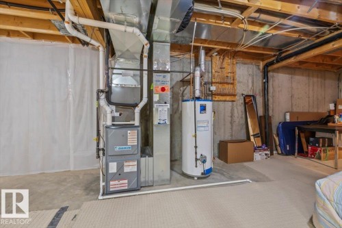 Daikin HVAC system with extensive ductwork, water heater, exposed concrete foundation walls, and visible wood joists - #92 13320 124 St Nw, Edmonton, AB 