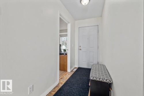 Front entry with a four-panel door, overhead light fixture, and wood-finish flooring - #92 13320 124 St Nw, Edmonton, AB 
