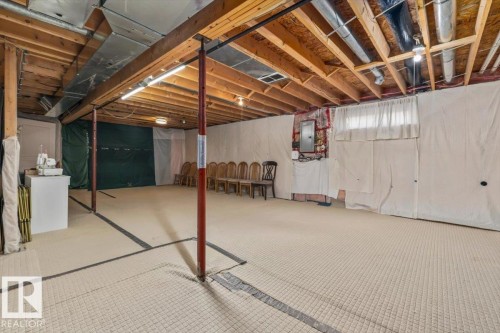 Unfinished basement space featuring exposed wooden joists, utility piping, and a concrete floor - #92 13320 124 St Nw, Edmonton, AB 