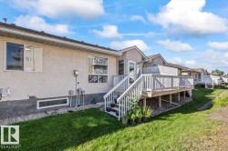 Rear exterior with stucco siding, an elevated wood deck, and a white deck railing - 