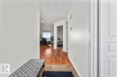 Interior hallway featuring wood-finish flooring, light-toned walls, and recessed lighting - #92 13320 124 St Nw, Edmonton, AB 