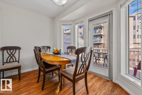 Bay window dining area with wood-finish flooring and a glass-paneled door - #92 13320 124 St Nw, Edmonton, AB 