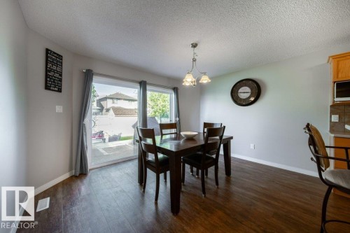 Wood-finish flooring, glass sliding door with backyard access, and a ceiling-mounted light fixture - 16120 138 Street Nw, Edmonton, AB 