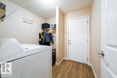 Wood-finish flooring, white paneled door, and built-in overhead shelving - 16120 138 Street Nw, Edmonton, AB 