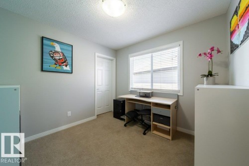 Neutral wall paint, textured ceiling, carpet flooring, a white paneled door, and a window with blinds - 16120 138 Street Nw, Edmonton, AB 