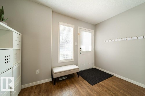 Wood-finish flooring, light gray wall color, white trim, and a white door with an integrated glass panel - 16120 138 Street Nw, Edmonton, AB 