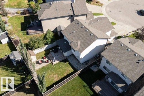 Fenced backyard with a wooden deck, paver patio, and detached storage shed - 16120 138 Street Nw, Edmonton, AB 