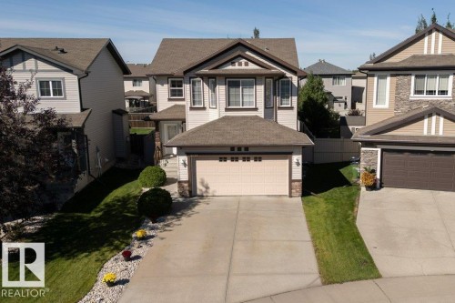 Multi-level roofline, exterior siding with stone accents, attached garage, concrete driveway, and landscaped front yard - 16120 138 Street Nw, Edmonton, AB 