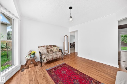 Wood-finish flooring, white walls, and a contemporary pendant light fixture - 8224 186 Street Nw, Edmonton, AB 