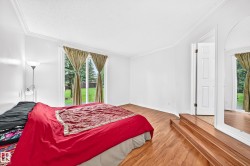 Wood-finish flooring throughout, white walls, and crown molding - 