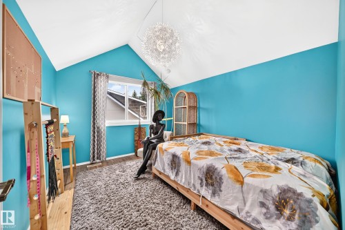 Vaulted ceiling with an attached light fixture, wood-finish flooring, and a window with curtains - 8224 186 Street Nw, Edmonton, AB 