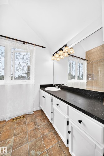 White vanity with black hardware, black countertop, and integrated sink - 8224 186 Street Nw, Edmonton, AB 
