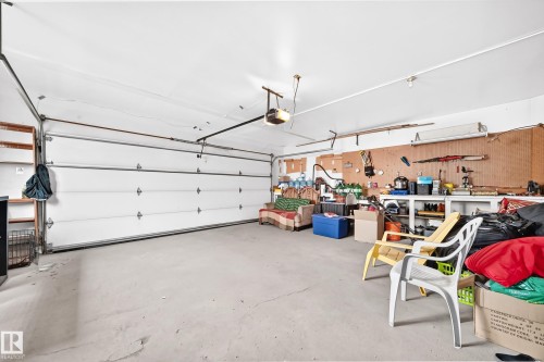 Garage with concrete flooring, a paneled garage door, and built-in shelving - 8224 186 Street Nw, Edmonton, AB 