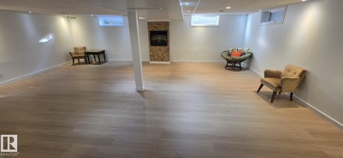 Expansive finished lower level featuring wood-finish flooring, recessed lighting, and a stone-clad fireplace - 8224 186 Street Nw, Edmonton, AB 
