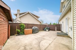 Paved patio area, brown privacy fencing, and wood-sided shed - 