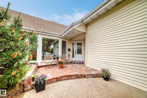 Front entry with brick patio, a covered porch, and a white entry door with decorative glass - 8224 186 Street Nw, Edmonton, AB 